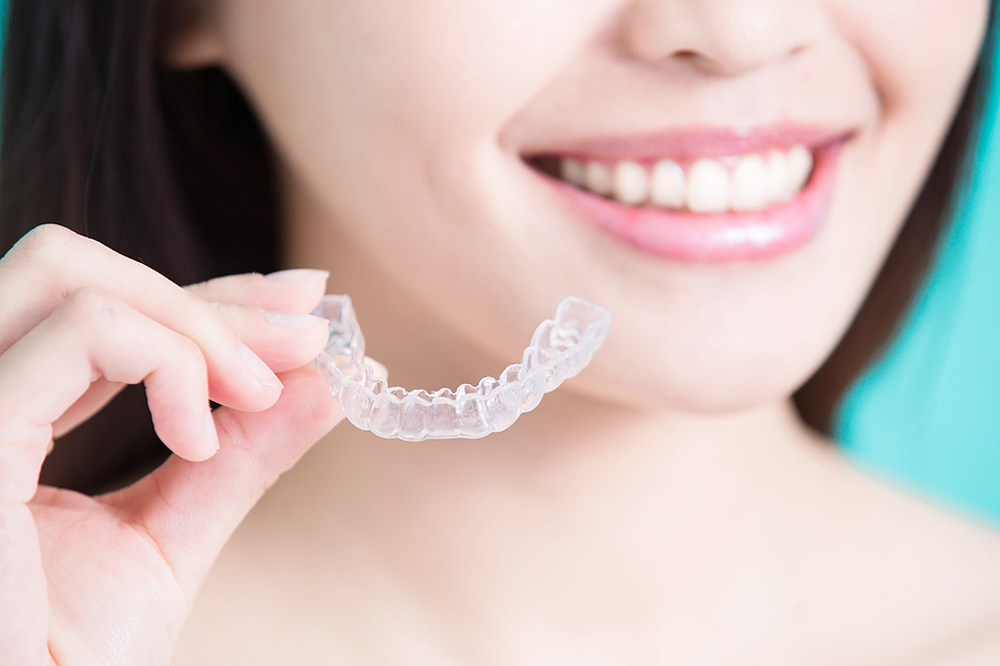 woman take invisible braces on the green background