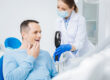 A dentist talking with a patient in Calgary, AB.